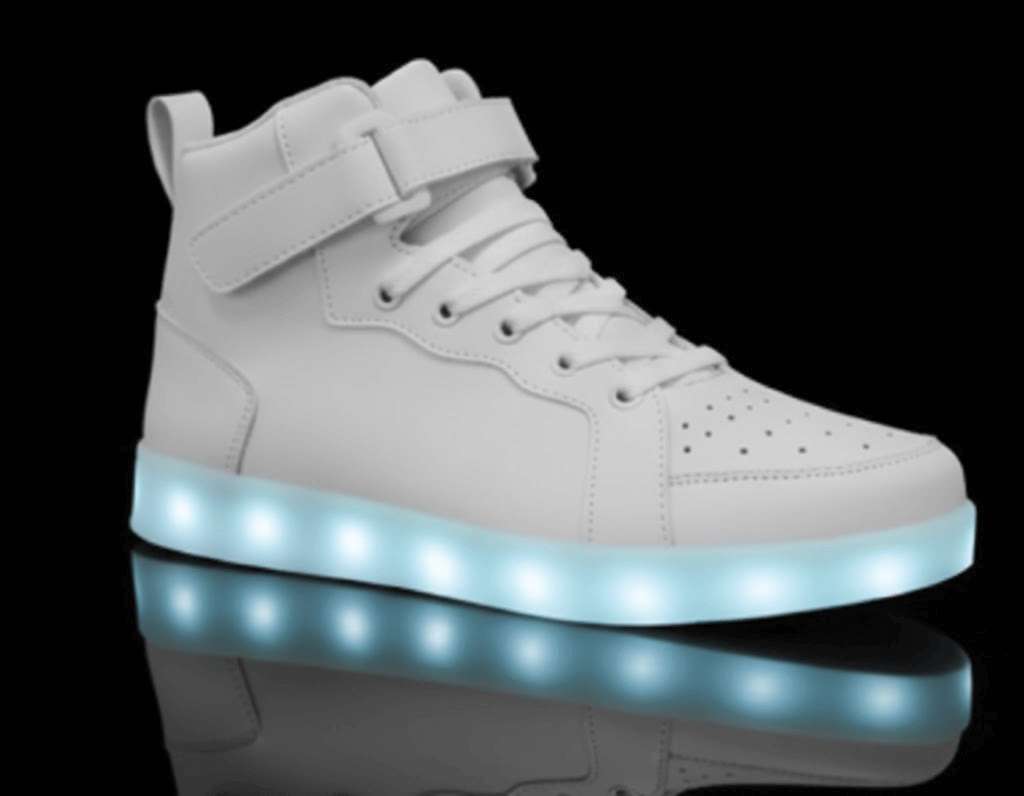 A white high-top sneaker with a glowing LED sole, perfect as light up shoes for kids, displayed against a black background.
